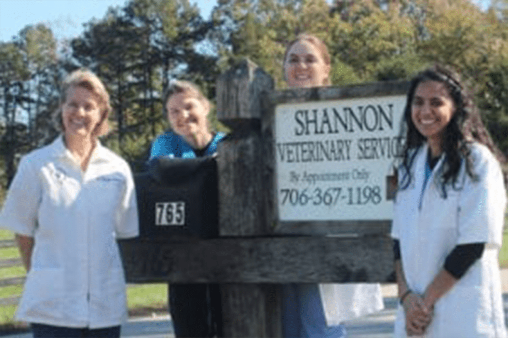 Veterinary team standing by service sign.