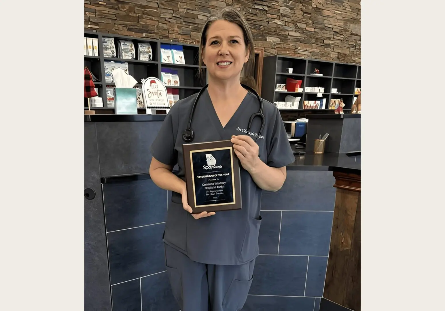 Smiling vet with stethoscope and plaque
