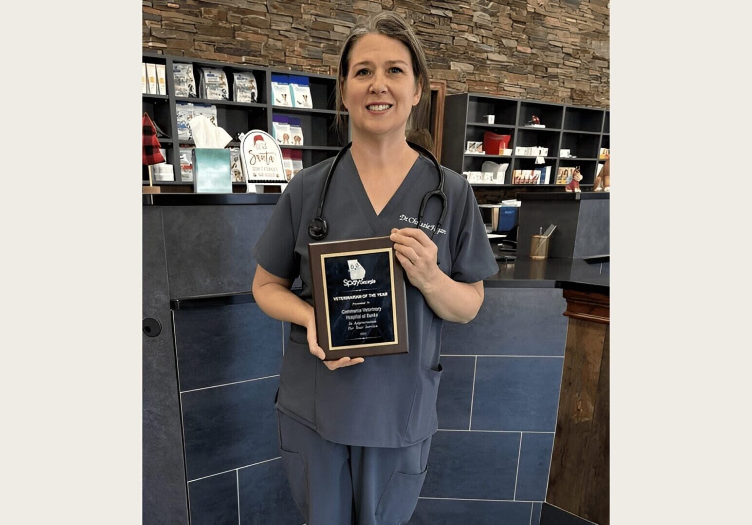 Smiling vet with stethoscope and plaque